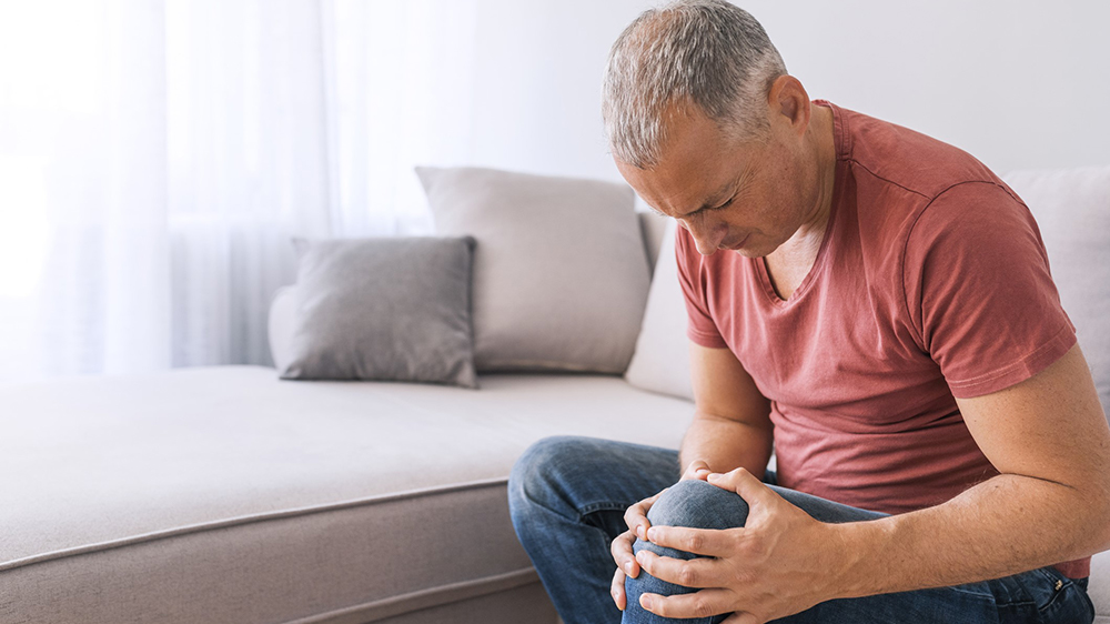 Gentleman holding his knee in pain