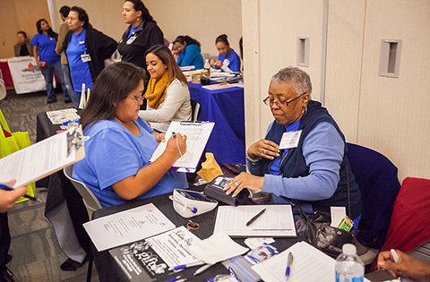 People gathered at tables signing forms