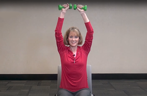 A woman lifting barbells over her head
